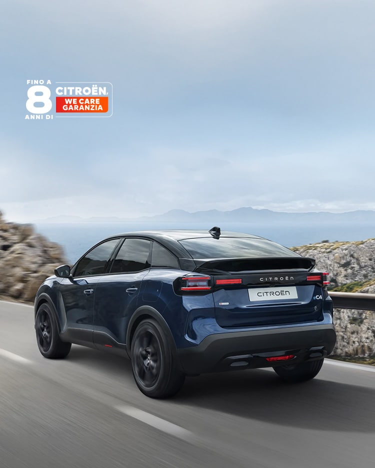 Vista frontale posteriore a tre quarti in guida dell'ë-C4 che mette in evidenza il design crossover aerodinamico, efficienza e stile per una presenza moderna e premium.