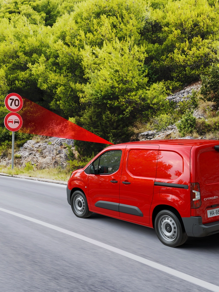Furgone rosso che rileva più segnali stradali lungo il percorso, con riconoscimento esteso dei limiti di velocità e indicazioni consigliate visualizzate a bordo.