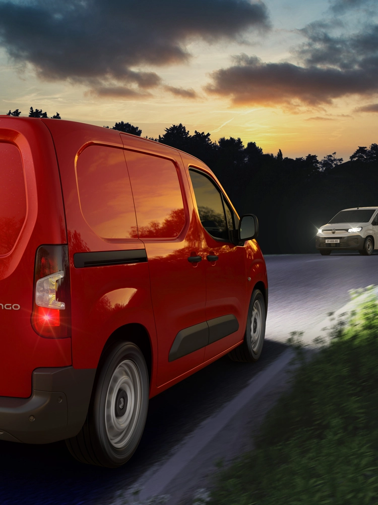 Berlingo Van rosso in movimento di notte su una strada di campagna, con assistenza automatica agli abbaglianti che rileva i veicoli in arrivo e regola i fari.