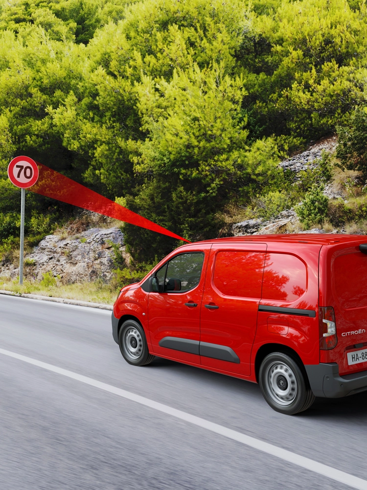 Berlingo Van in movimento su una strada di campagna con sistema di riconoscimento della segnaletica che mostra il limite di velocità e la velocità consigliata.