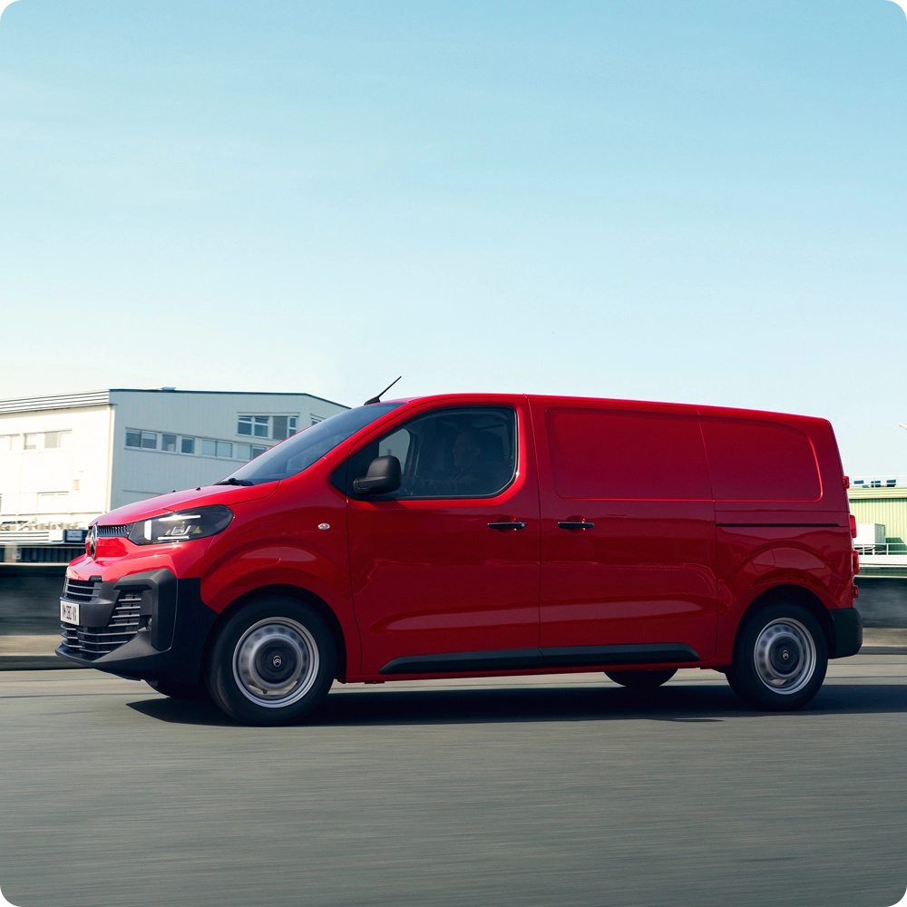 Vista posteriore a tre quarti di Citroën ë-Jumpy in movimento su strada, che esprime un design elettrico efficiente, libertà di movimento e una presenza sicura.