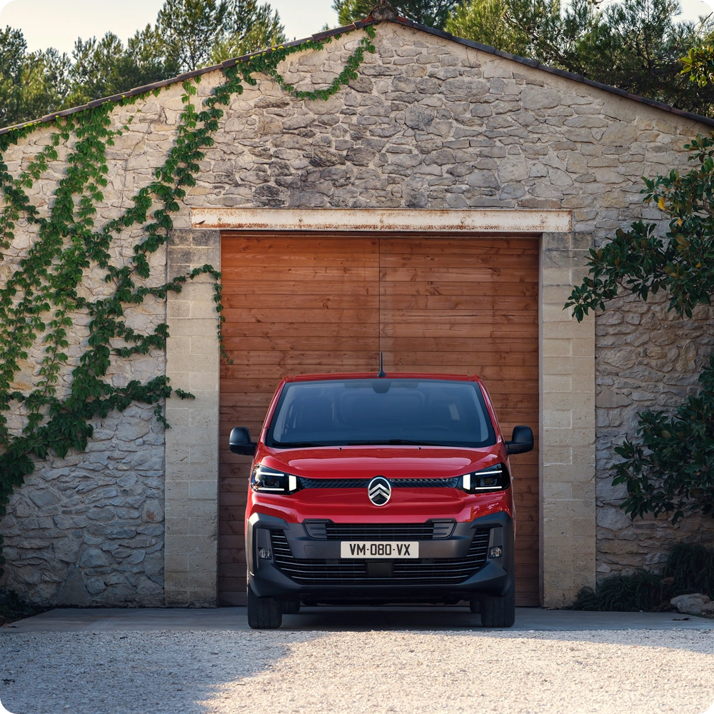 Vista frontale di Citroën Jumpy rosso parcheggiato davanti a un edificio, che mette in evidenza design professionale, robustezza, praticità e una presenza sicura.