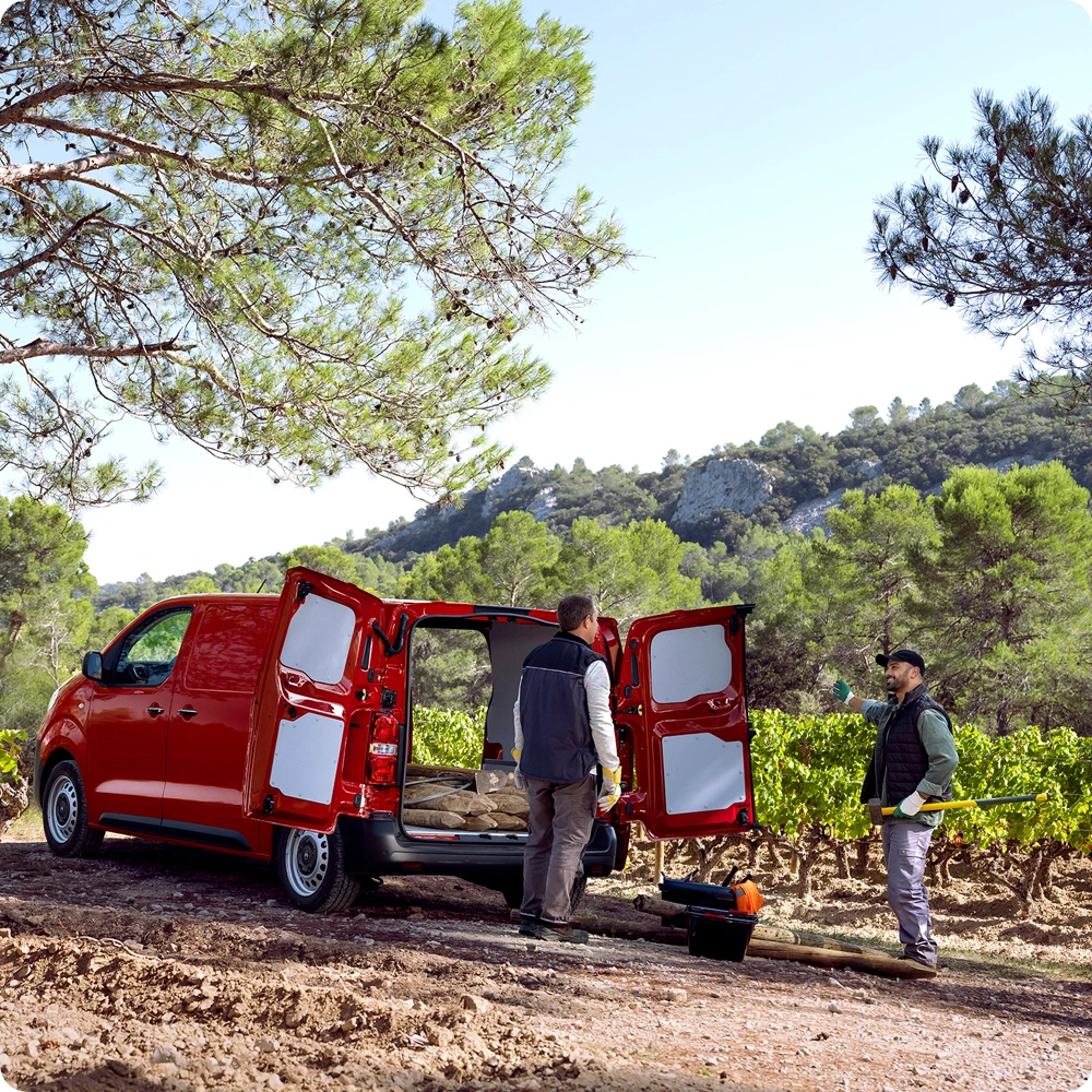 Vista esterna posteriore a tre quarti di Citroën Jumpy rosso con porte posteriori aperte durante le operazioni di carico, che evidenzia versatilità del vano, accesso pratico e idoneità all’uso professionale.