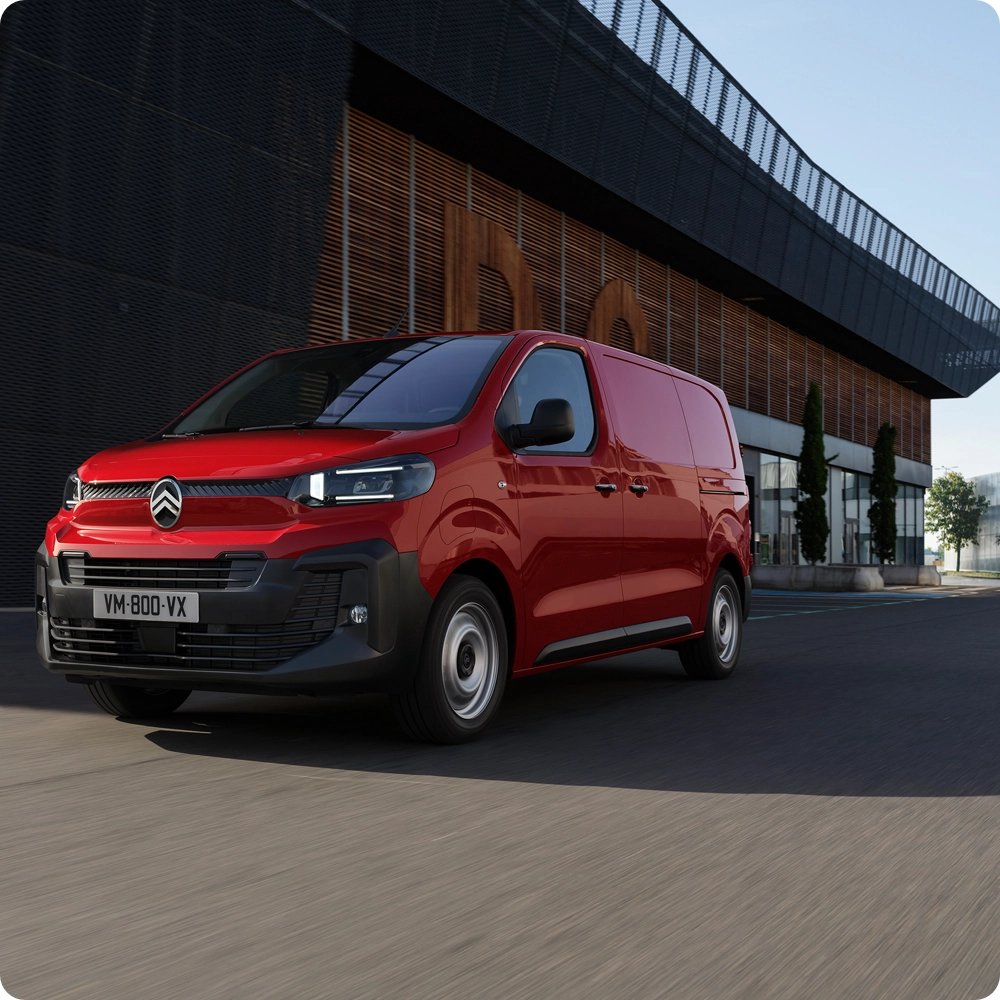 Vista frontale a tre quarti di Citroën Jumpy rosso in marcia in contesto urbano, che evidenzia design moderno, comfort di guida, connettività e una presenza professionale sicura.