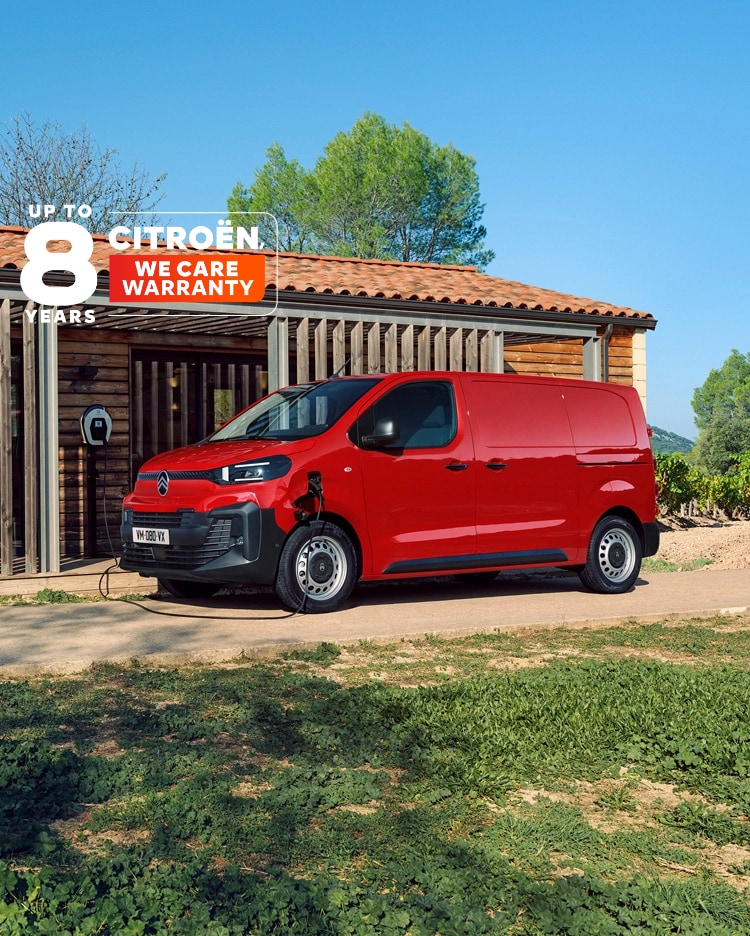 Vista laterale a tre quarti di Citroën ë-Jumpy rosso in ricarica davanti a un edificio, che esprime un design elettrico moderno, praticità quotidiana, connettività e una presenza professionale sicura.