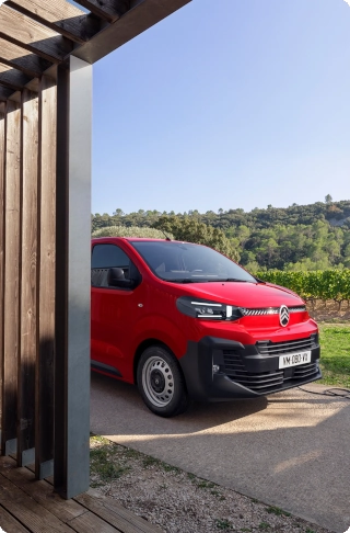 Vista esterna posteriore a tre quarti di un Citroën Jumpy rosso durante le operazioni di carico, che mette in evidenza un design robusto, un utilizzo intensivo quotidiano e un accesso al vano di carico pratico e funzionale.