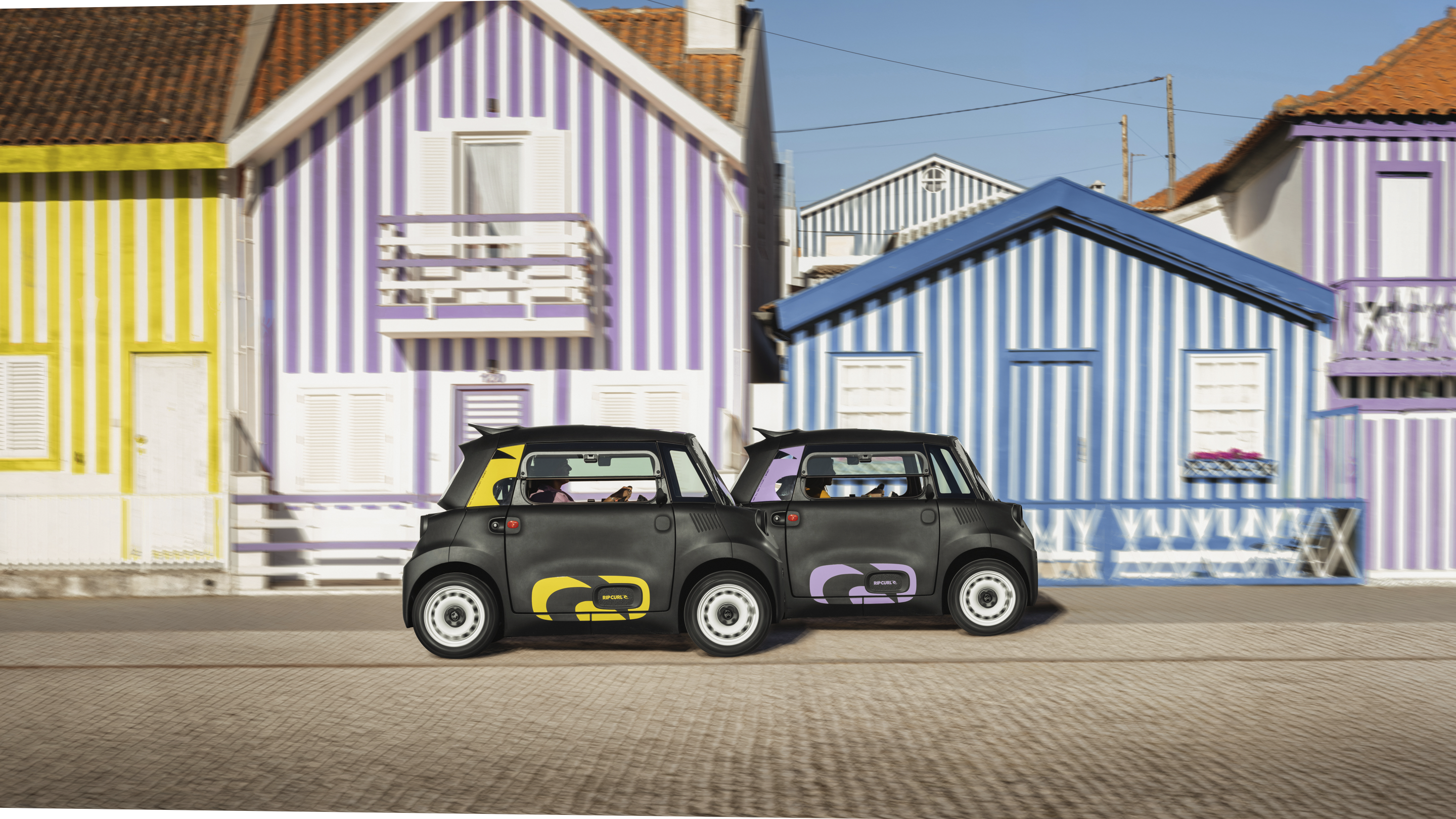 Vista stradale fianco a fianco Citroën Ami x Rip Curl elettrica senza patente, stile gemello Citroën Ami per auto elettrica urbana