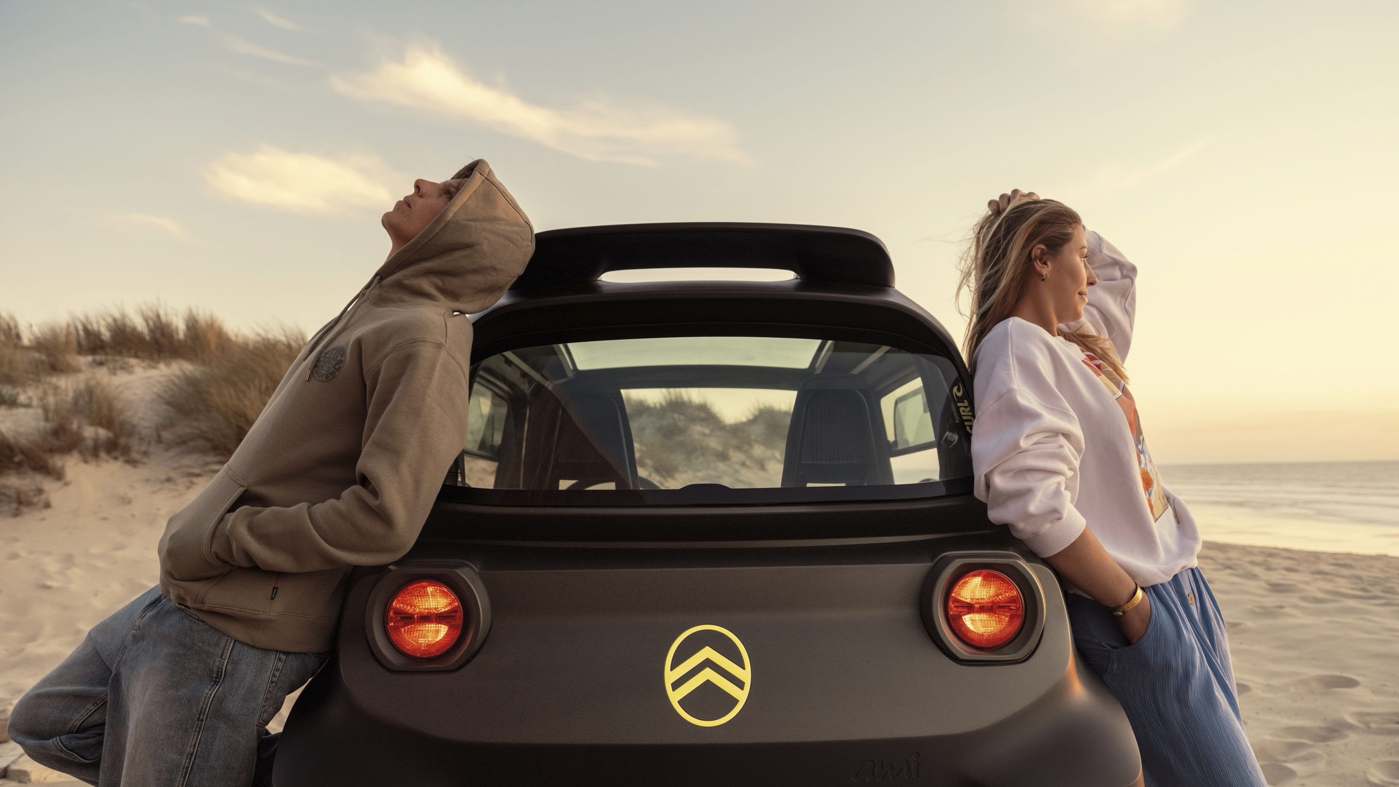 Vista lifestyle posteriore al tramonto Citroën Ami x Rip Curl elettrica senza patente, Citroën Ami libertà rilassata per auto elettrica urbana