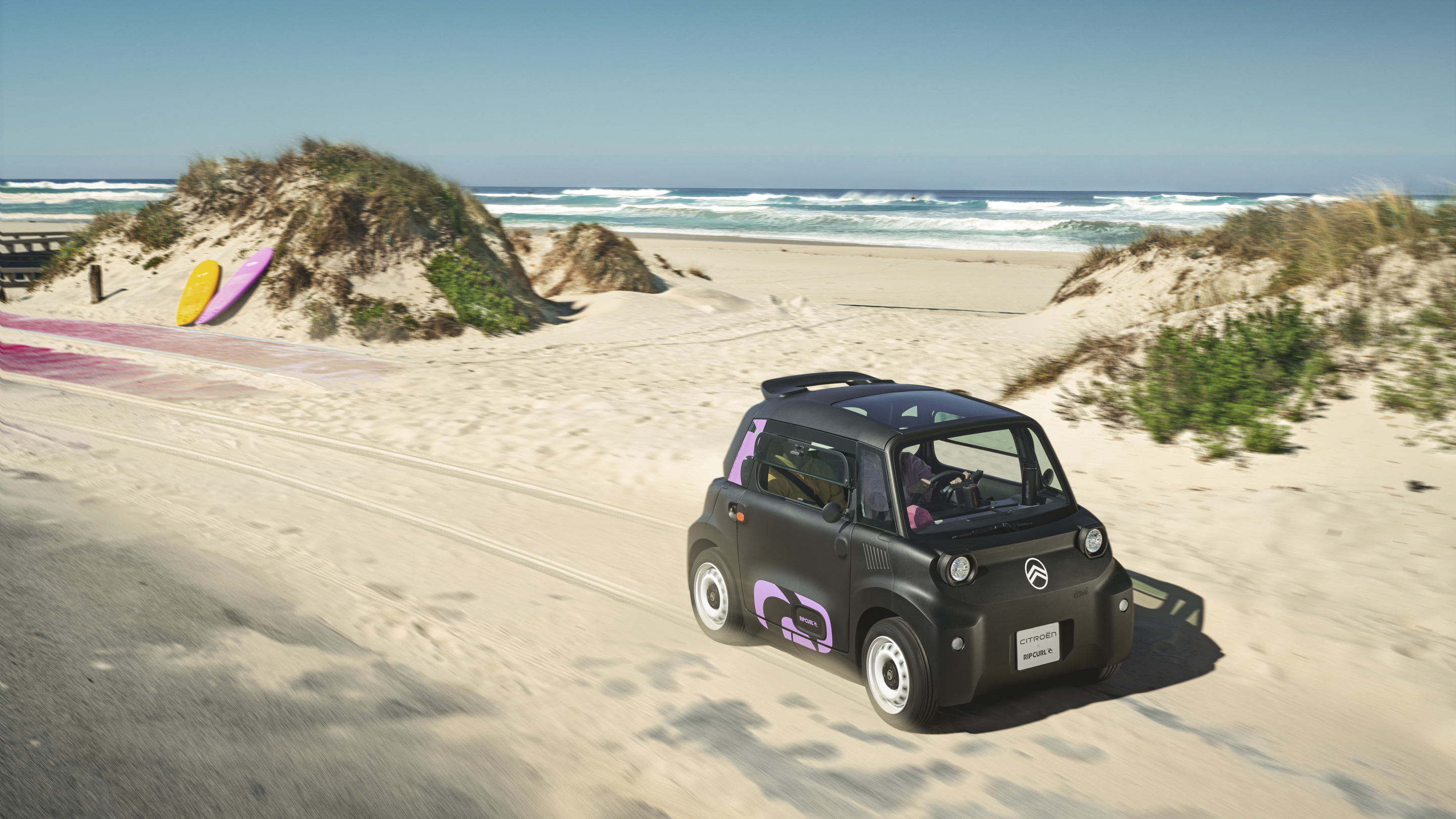 Vista frontale tre quarti in azione Citroën Ami x Rip Curl elettrica senza patente, Citroën Ami libertà per mobilità urbana elettrica