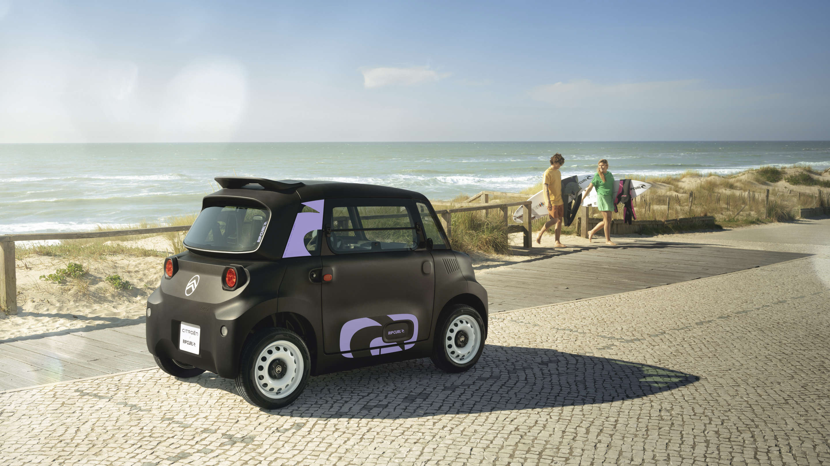 Vista posteriore tre quarti Citroën Ami x Rip Curl elettrica senza patente, Citroën Ami libertà costiera per mobilità urbana elettrica