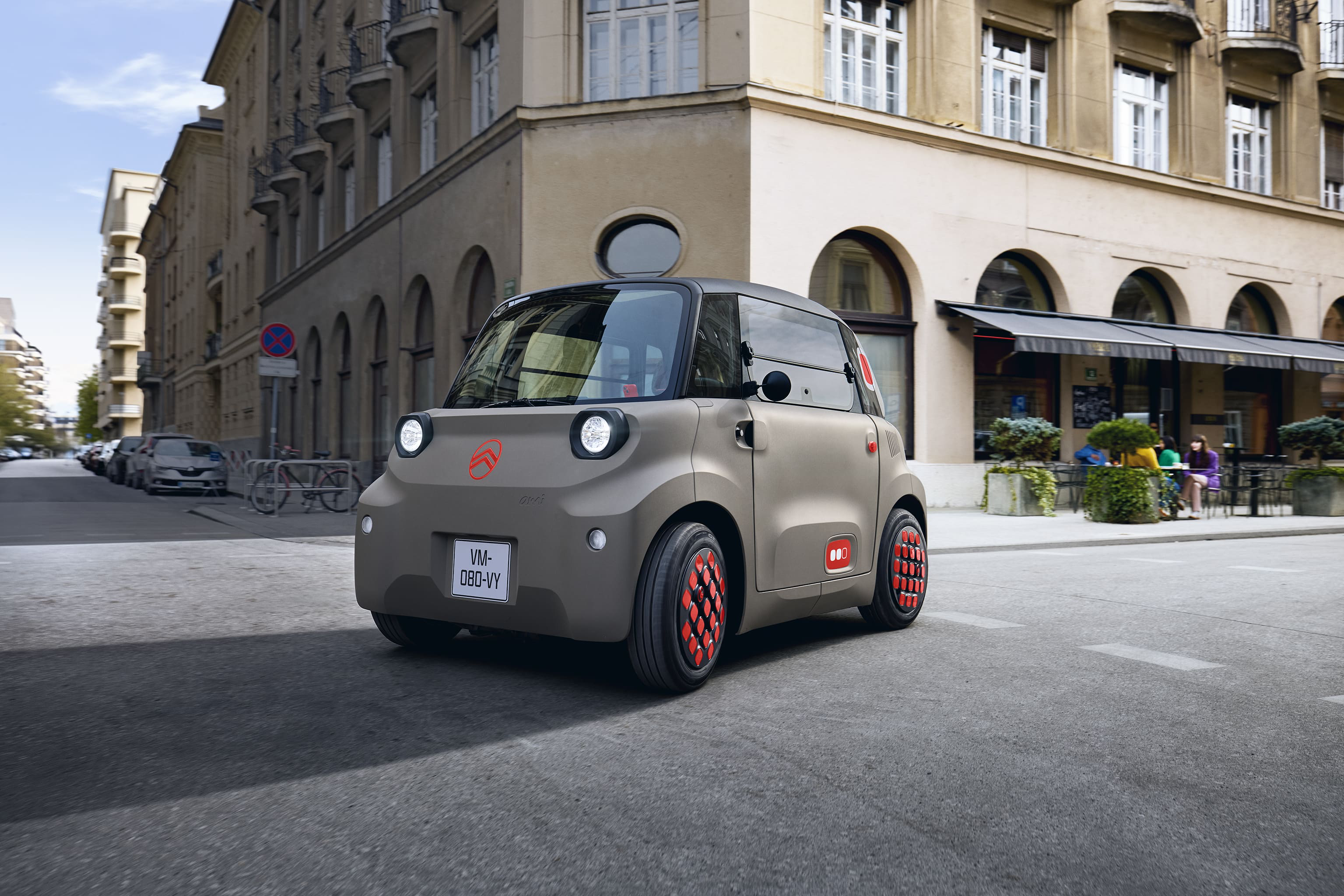 Vista frontale tre quarti su strada di Citroën Ami, che rivela un design elettrico compatto, sicuro e affidabile, pensato per offrire una maggiore libertà urbana.