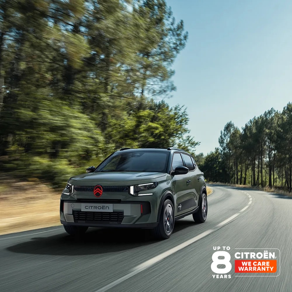 Vista anteriore a tre quarti di Citroën ëC3 Outdoor con firma luminosa a LED, che mostra il Citroën Advanced Comfort durante un viaggio panoramico