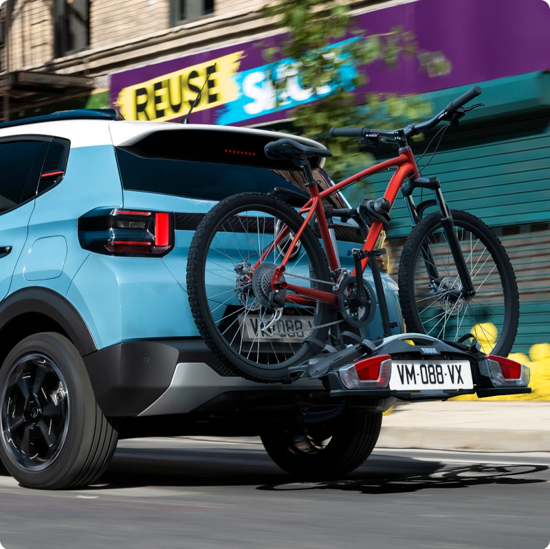 Vista posteriore di Citroën C3 con portabici posto sul gancio traino, per un trasporto semplice delle biciclette e una mobilità quotidiana versatile e attiva.