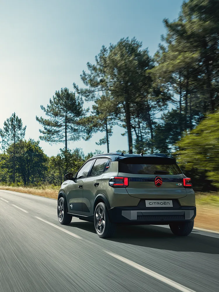 Vista posteriore a tre quarti di Citroën C3 Outdoor, con fanali posteriori a LED, che mostra questo SUV compatto Advanced Comfort su una strada aperta