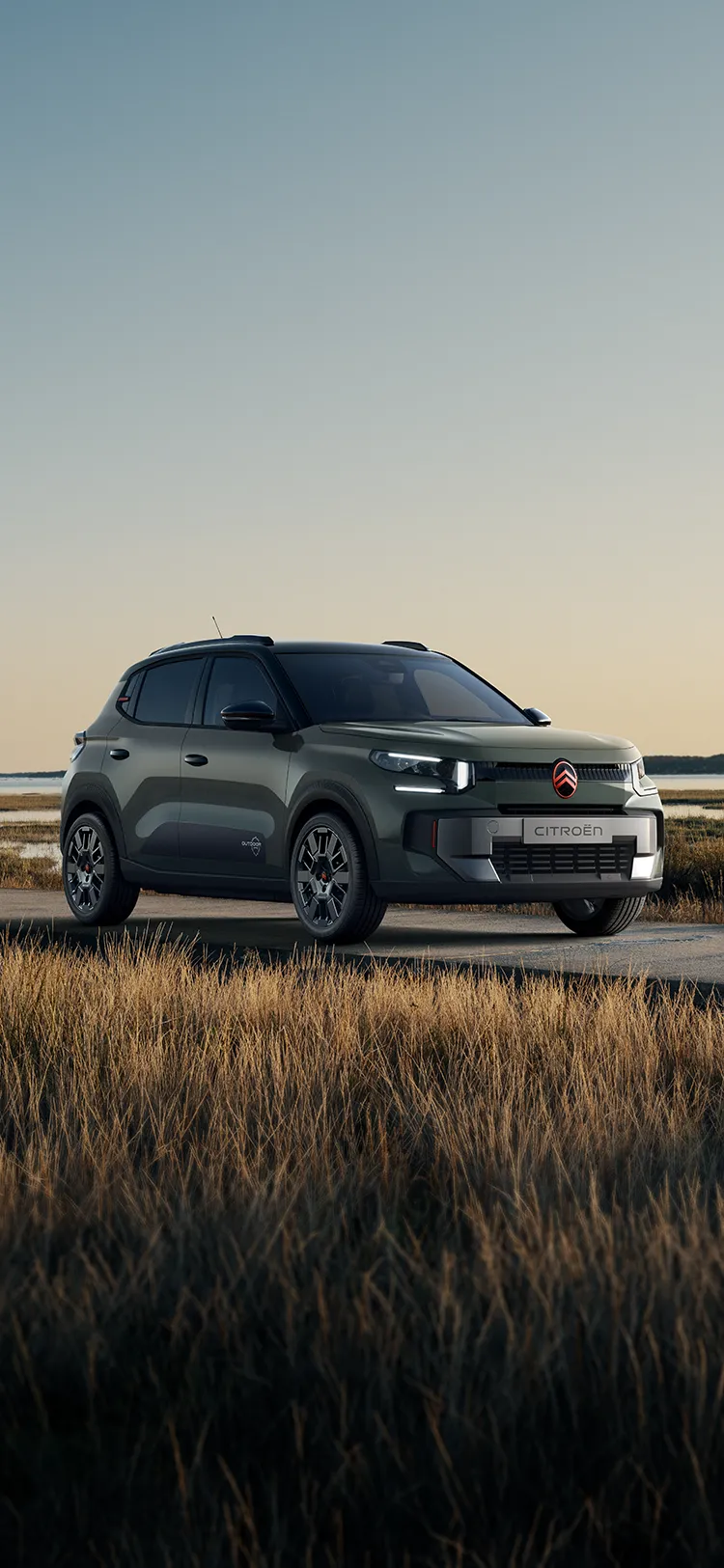 Vista anteriore a tre quarti di Citroën C3 Outdoor con firma luminosa a LED, che mostra questo SUV Advanced Comfort accanto a zone umide costiere