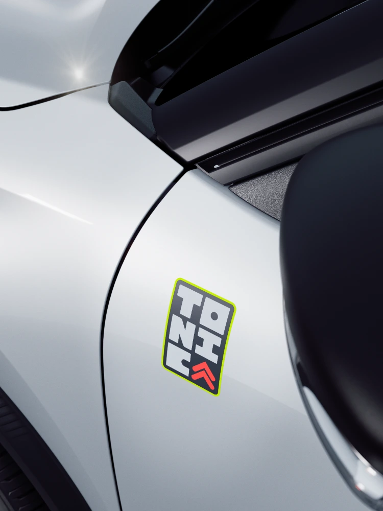 Dettaglio del frontale di Citroën ë-C3 TONIC, con firma stilistica distintiva della griglia anteriore e clip colorate esclusive.
