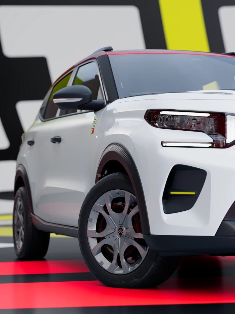 Dettaglio della vista anteriore a tre quarti di Citroën ë-C3 TONIC, con focus su design dei cerchi e protezioni della carrozzeria.