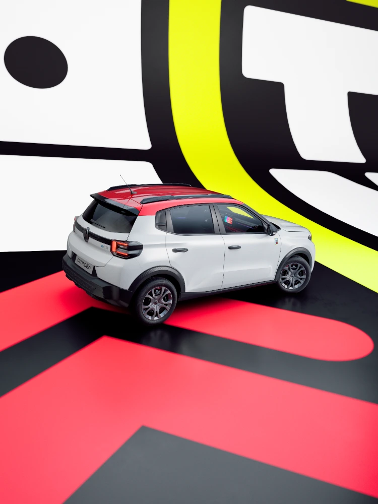 Vista posteriore a tre quarti di Citroën ë-C3 TONIC, edizione speciale della city car elettrica, in studio con design deciso e compatto.