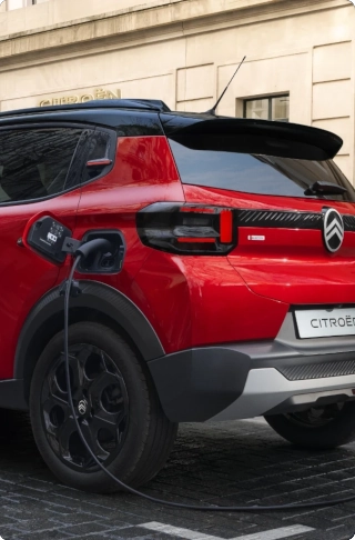 Vista laterale di Citroën ë-C3 che evidenzia la facilità di accesso alla ricarica della batteria, per una mobilità urbana quotidiana pratica, efficiente e accessibile.