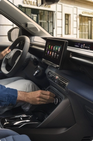 Vista interna della Citroën C3 compact SUV che mette in evidenza l'infotainment avanzato e i comandi al volante per il comfort quotidiano, alternativa EV intelligente.
