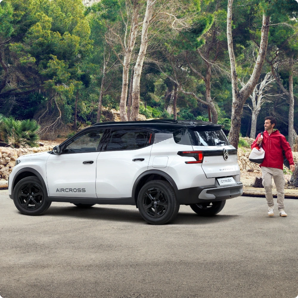 Vista frontale e posteriore a tre quarti outdoor della Citroën ë-C3 Aircross SUV elettrica che mette in evidenza l'autonomia estesa per una mobilità sicura, efficiente e conveniente.