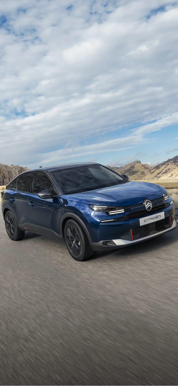 Vista frontale a tre quarti in guida dell'ë-C4 che mette in evidenza il design crossover aerodinamico, efficienza e stile per una presenza moderna e premium.