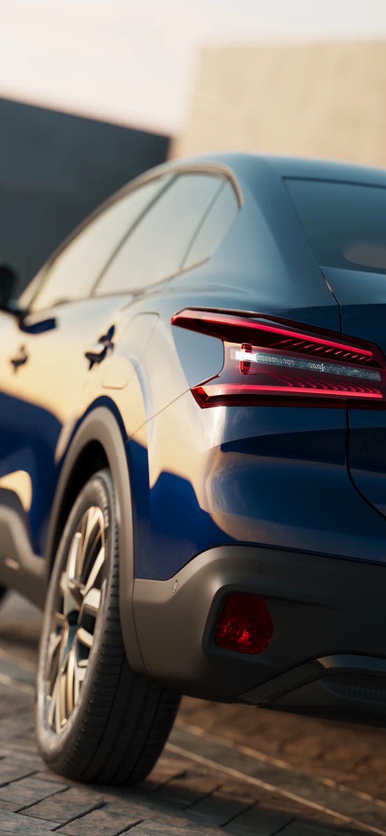 Close‑up of the Citroën ë‑C4 X rear light design illuminated in warm sunset lighting