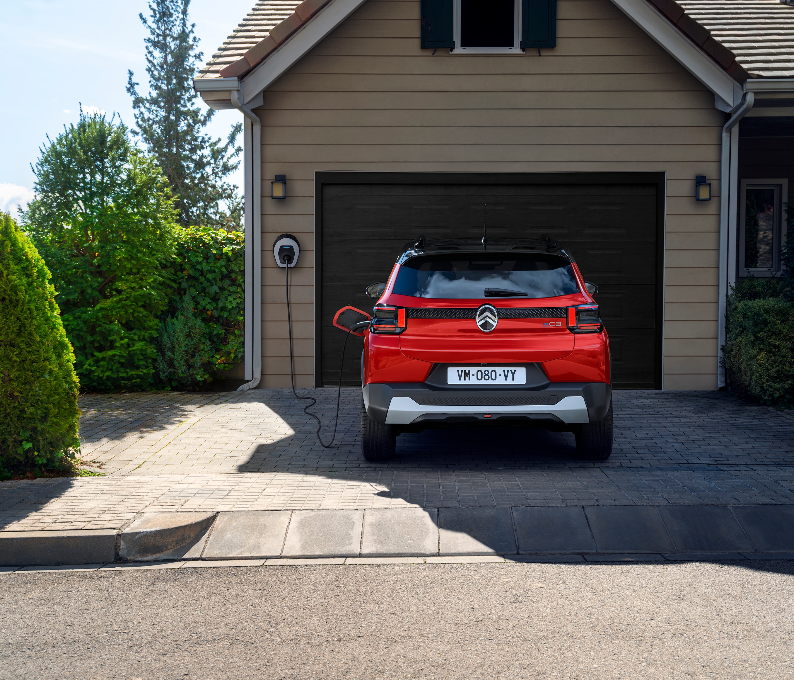 Vista posteriore di Citroën ë-C3 in ricarica domestica che evidenzia una mobilità urbana pratica, efficiente e accessibile.