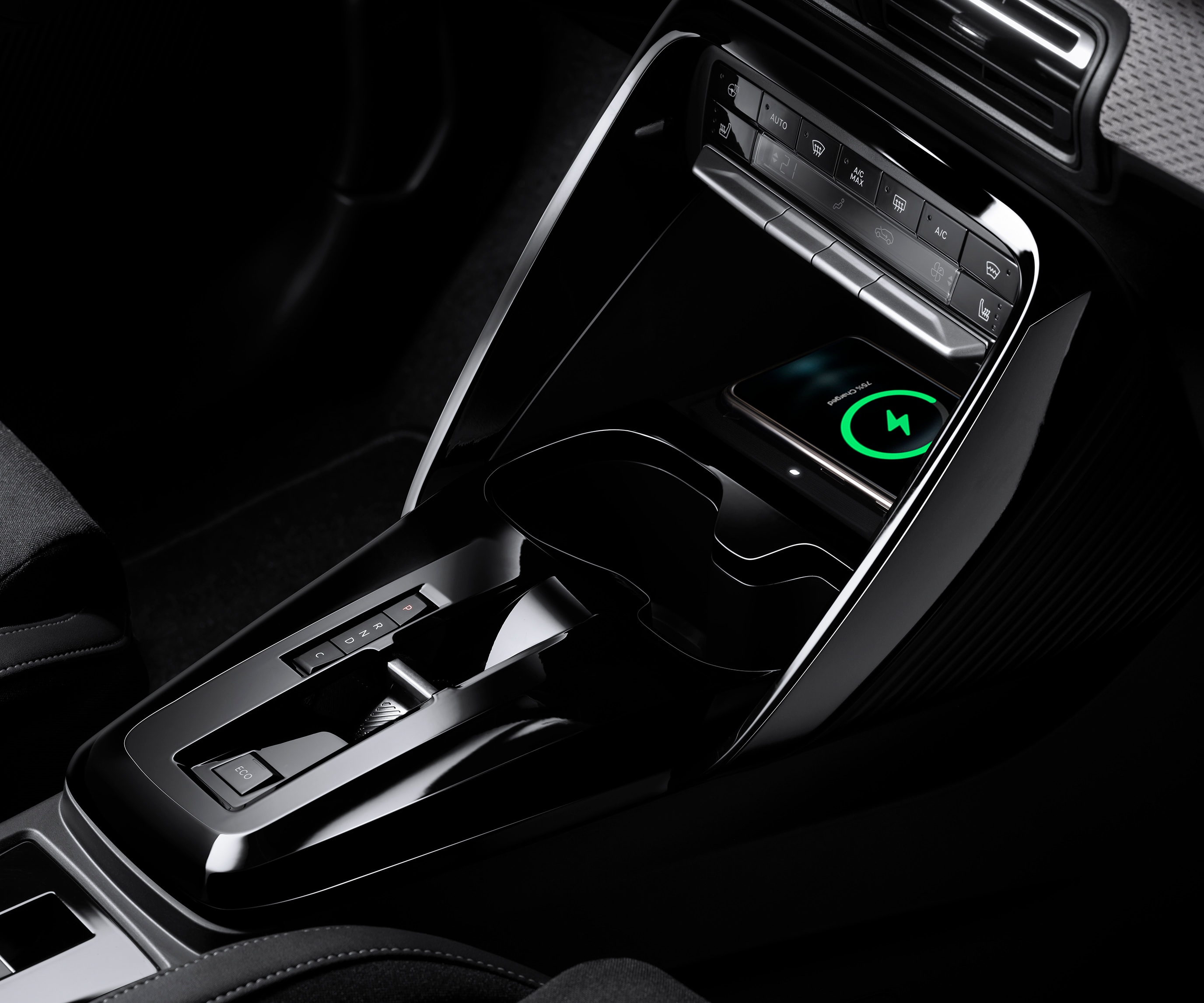 Vista ravvicinata della console di Citroën ë-C3 che mette in evidenza la ricarica wireless dello smartphone, per una mobilità quotidiana pratica e accessibile.