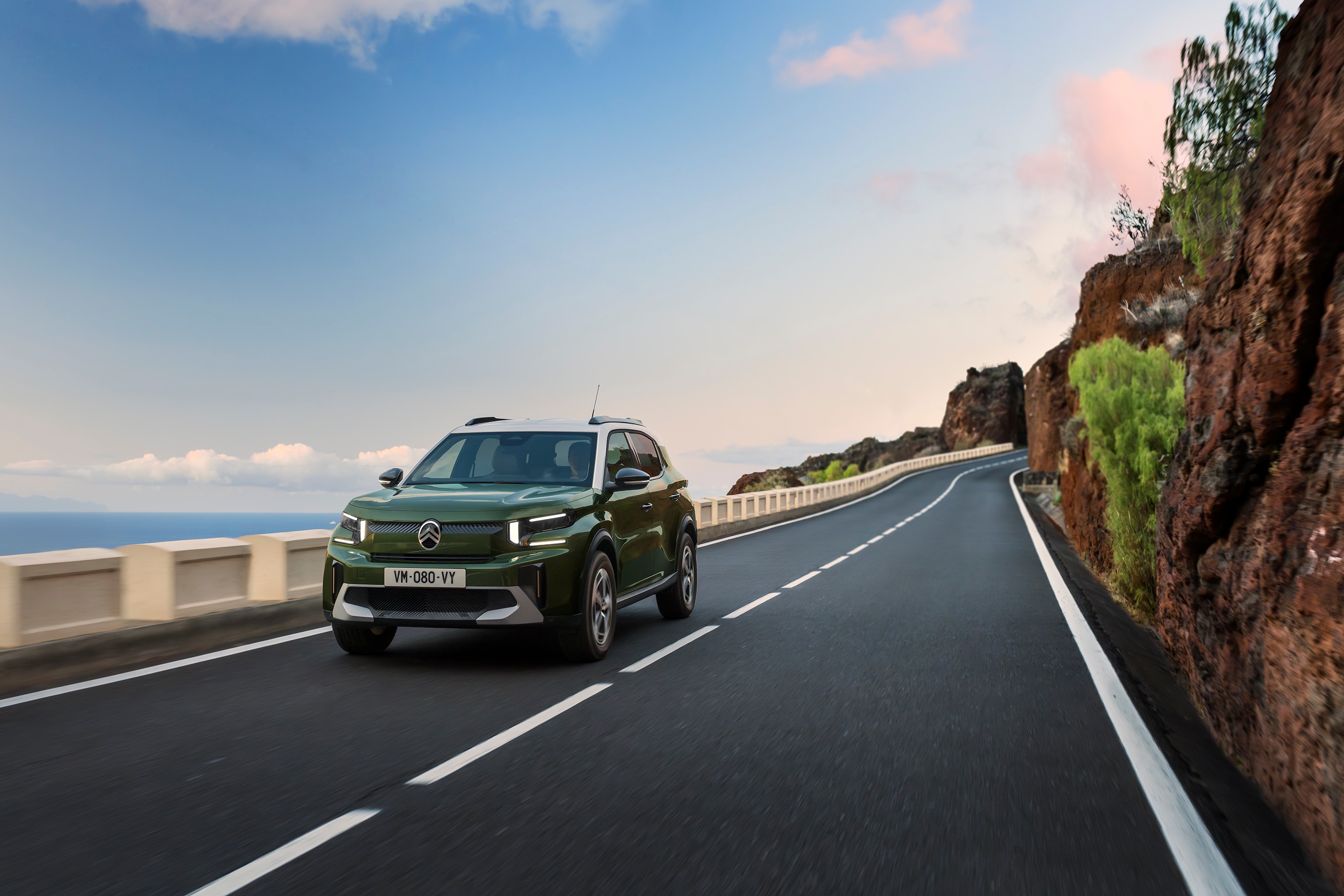 Vista anteriore di tre quarti in movimento di Citroën C3 su una strada panoramica che mette in risalto agilità, sicurezza e accessibilità, per una mobilità quotidiana pratica e conveniente.