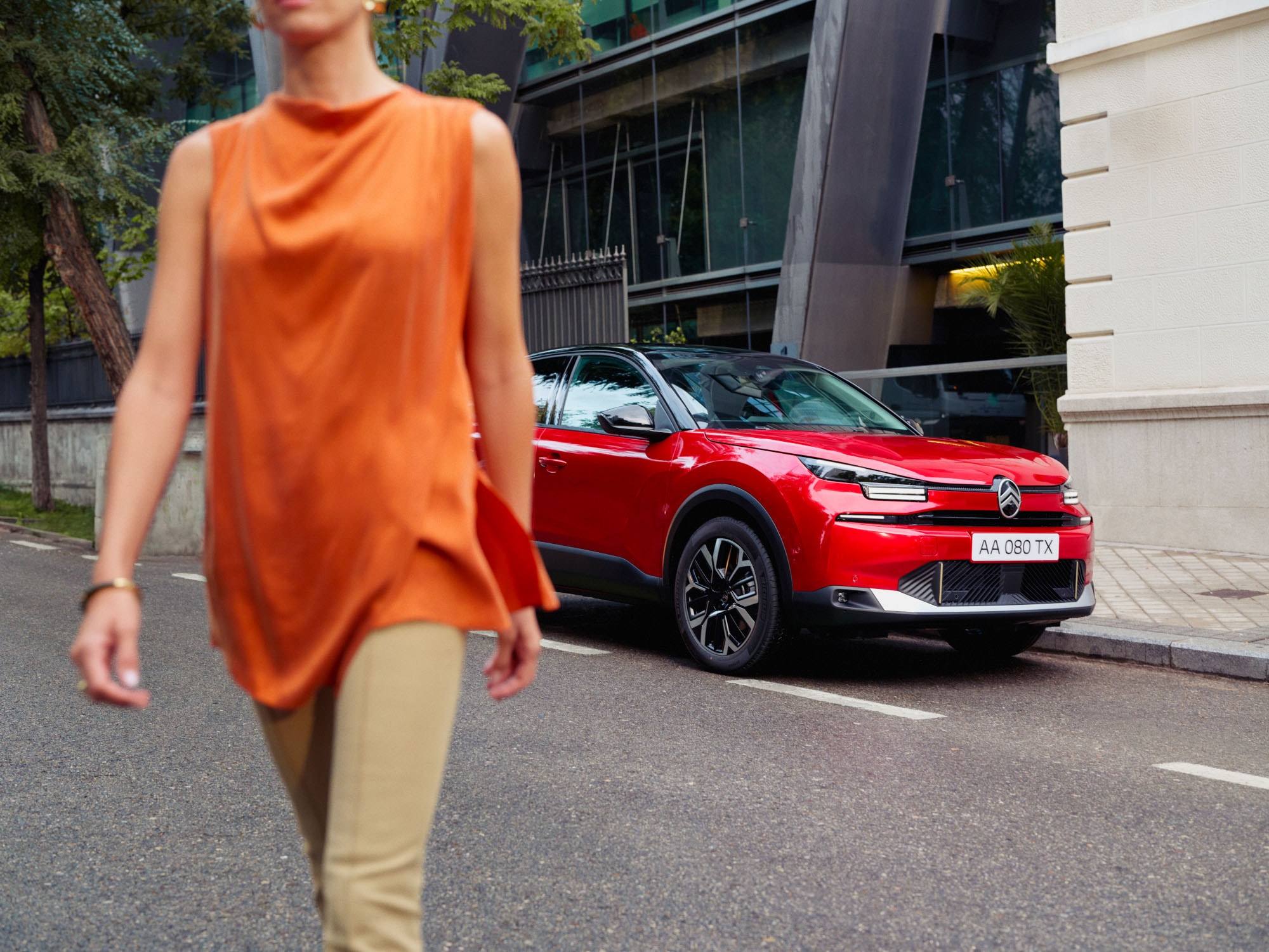 Vista anteriore di tre quarti di ë-C4 che mette in risalto il design elegante, la sicurezza, l’aerodinamica e il comfort, per una presenza urbana moderna e premium.