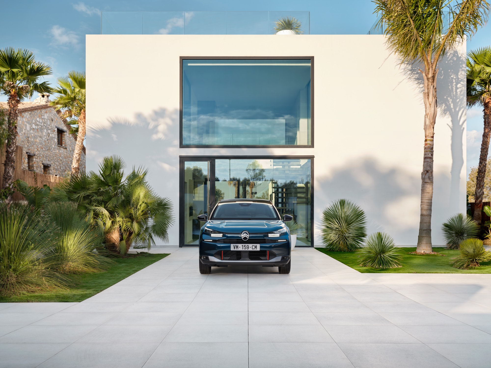 Vista frontale di ë-C4 Bleu Eclipse che mette in risalto il design elegante, la sicurezza e l’aerodinamica, per una presenza architettonica moderna e premium.