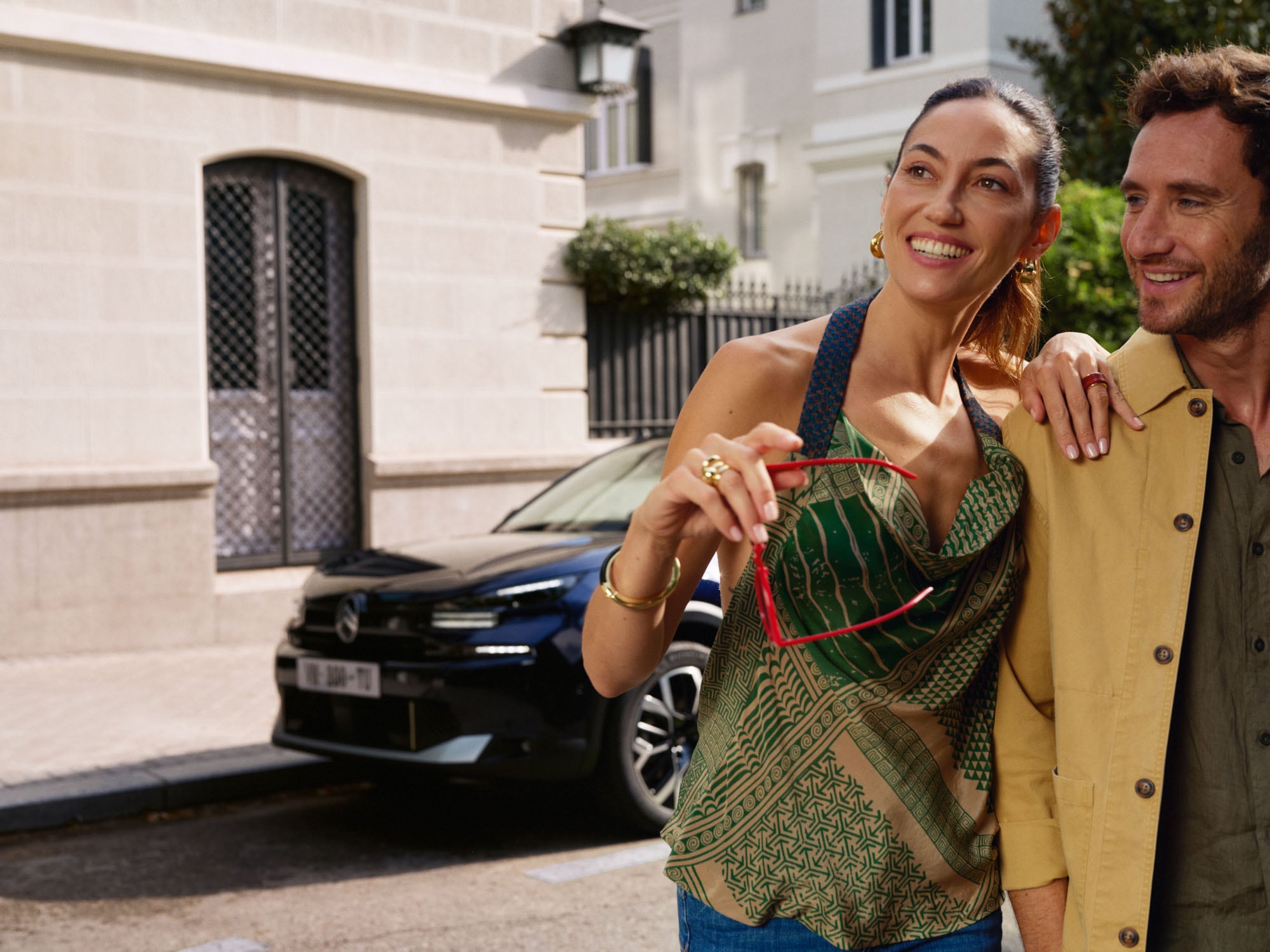 Scena lifestyle con la Citroën ë-C4 X parcheggiata nelle vicinanze, che illustra il suo design fastback moderno per una mobilità elegante e accessibile
