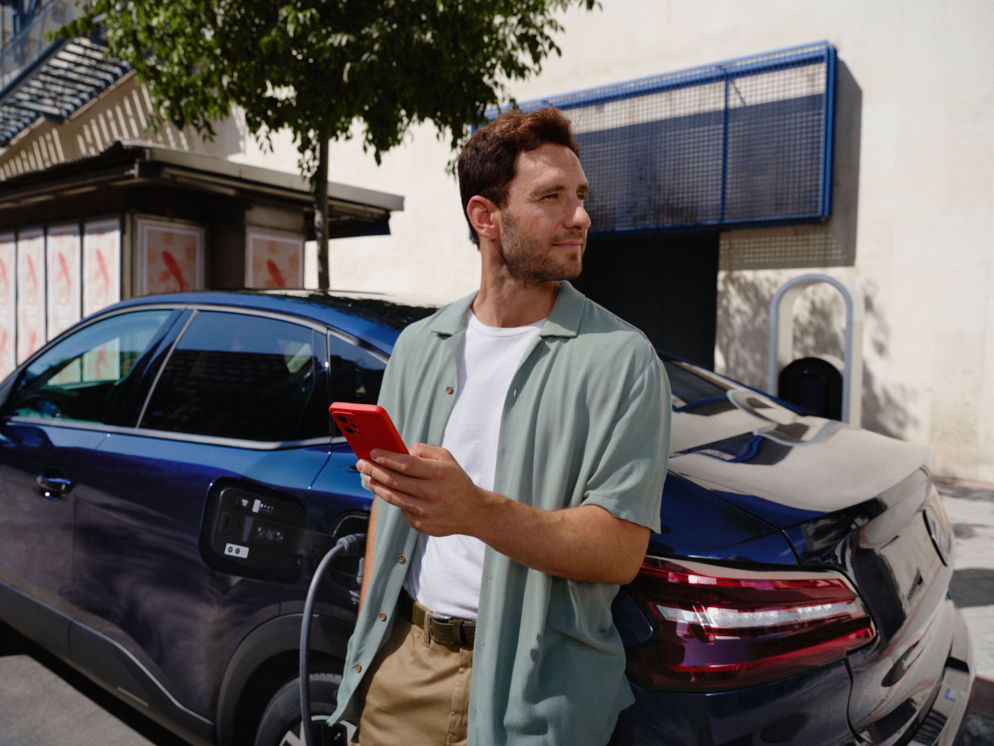 Scena di ricarica connessa della Citroën ë-C4 X fastback che mostra l'utilizzo dell'app intelligente per una mobilità elettrica quotidiana comoda