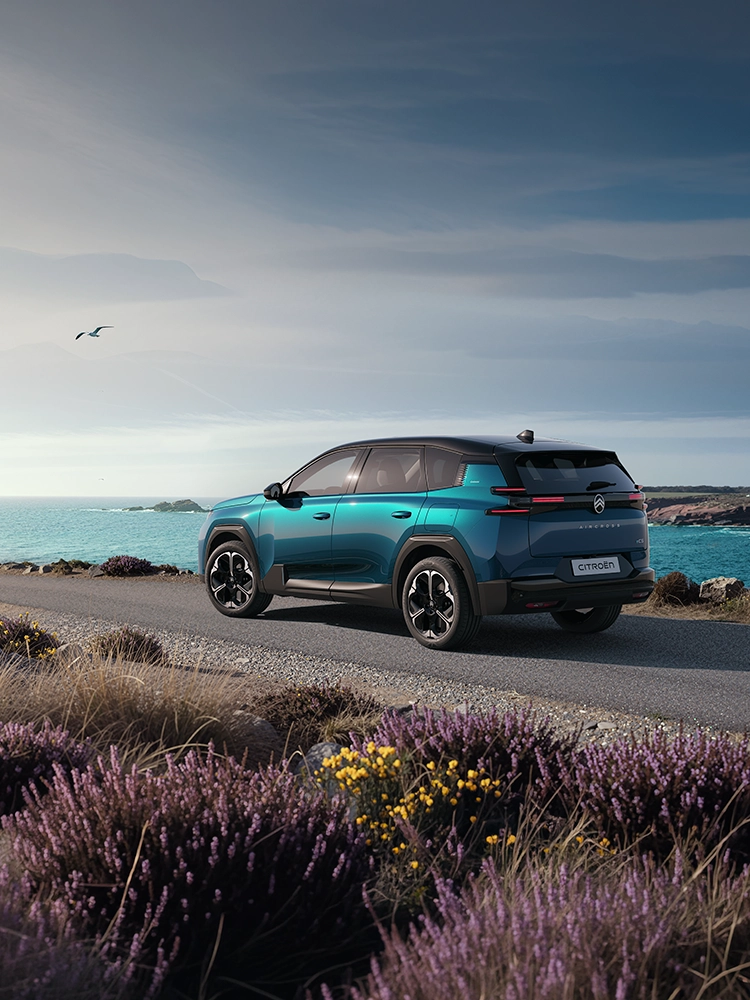 Vista posteriore a tre quarti Citroën C5 Aircross Emeraude mostra i distintivi fari posteriori a LED Light Wings di C5 Aircross, viaggio costiero del SUV familiare