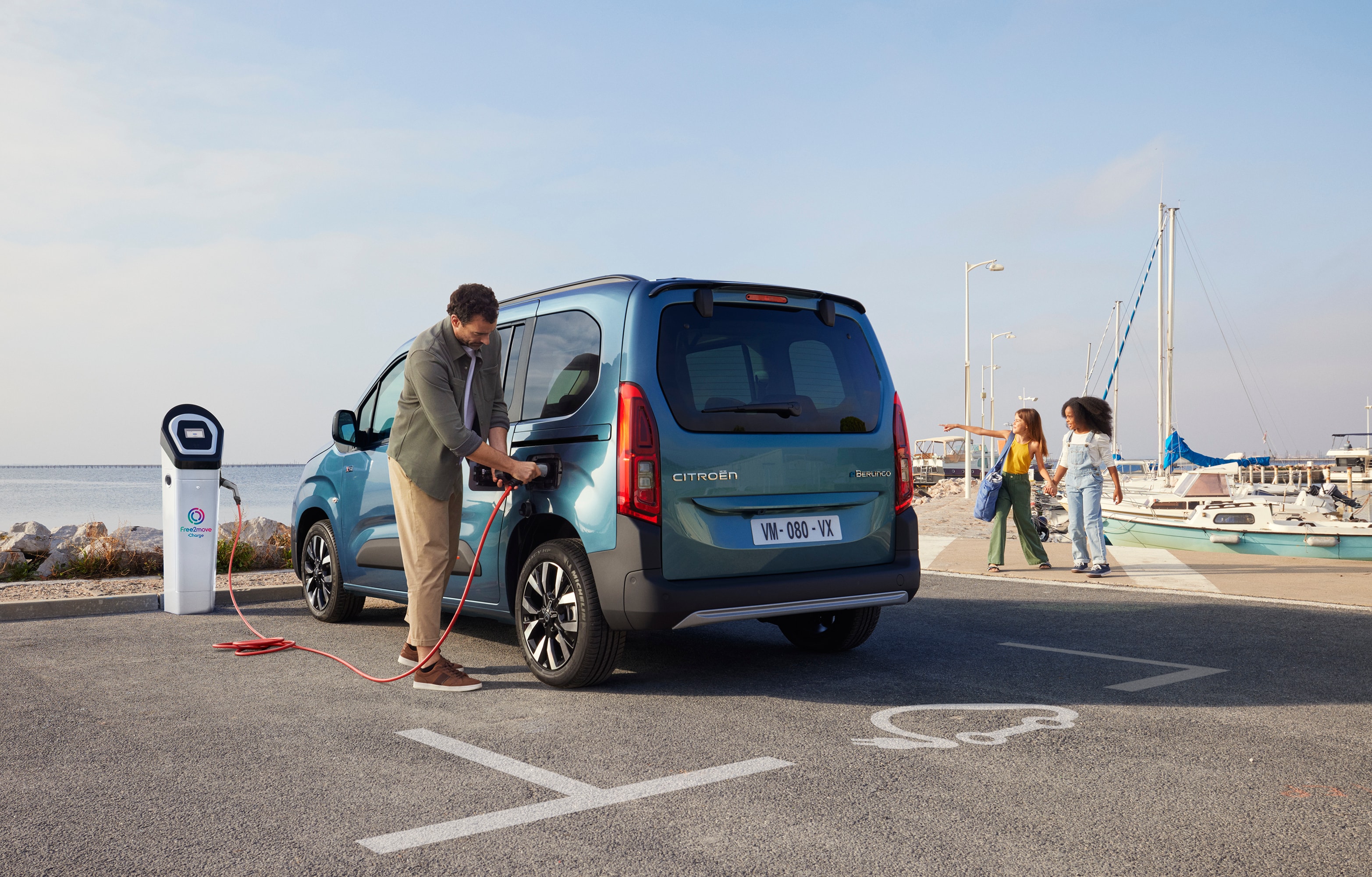 Vista posteriore a tre quarti del Berlingo in ricarica presso una stazione Free2move che mostra sicurezza, efficienza, tecnologia e uso sicuro