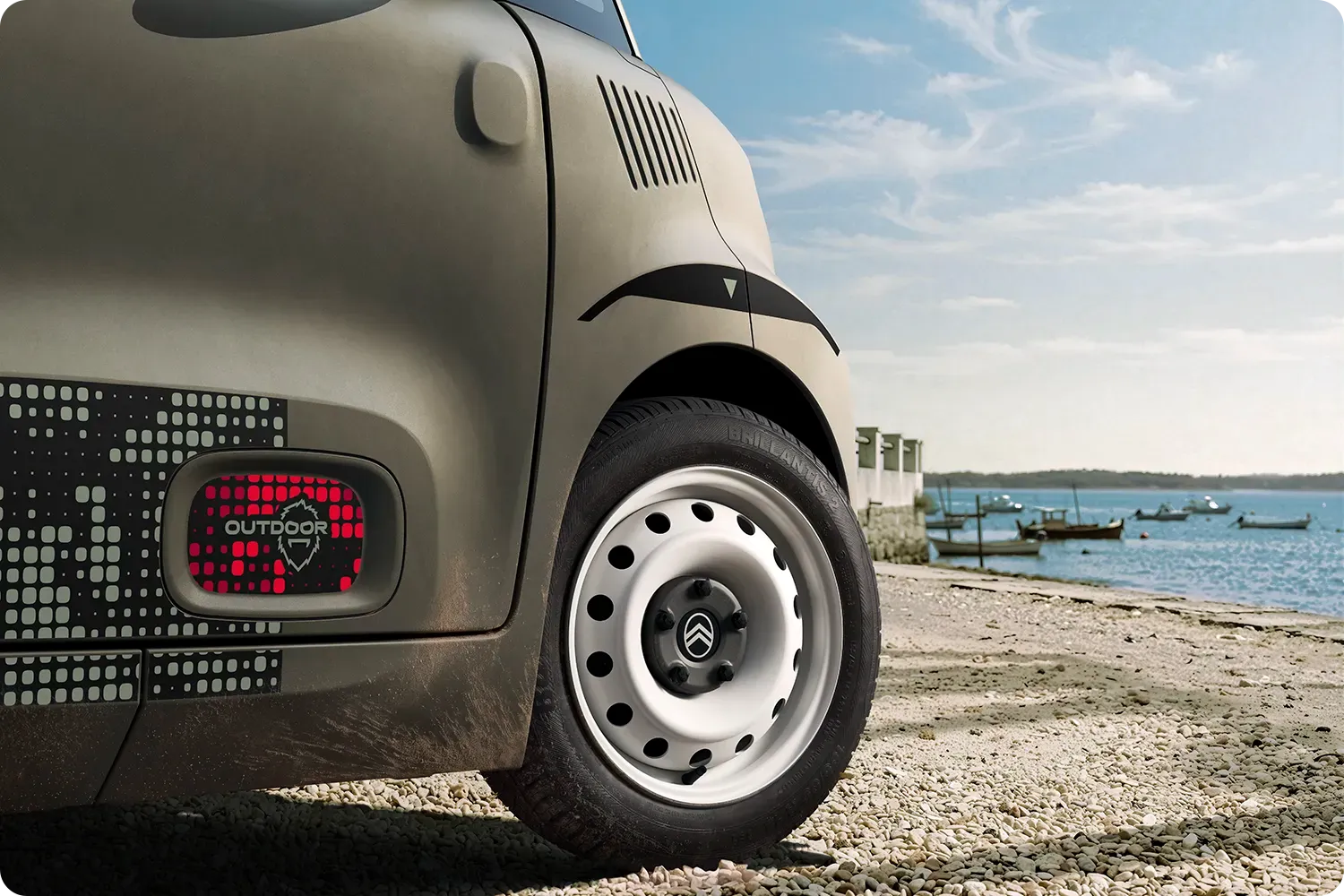 Primo piano del passaruota di Citroën Ami Outdoor, dal design compatto, elettrico e accessibile, con uno stile innovativo per le avventure sulla costa